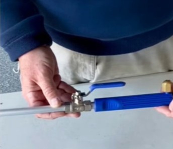 Close-up of the JetHose pressure nozzle showing the durable stainless steel wand and blue shut-off valve for easy water control
